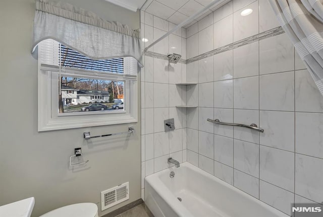 bathroom featuring ornamental molding, toilet, and tiled shower / bath