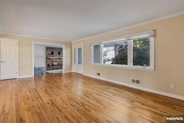 unfurnished living room with a fireplace, ornamental molding, and light wood-type flooring