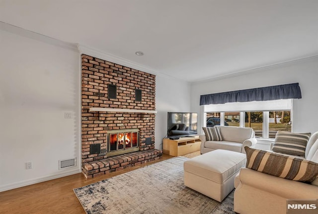 living room featuring crown molding, a fireplace, and hardwood / wood-style flooring