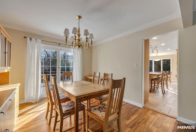 dining space featuring a notable chandelier, light wood-type flooring, and crown molding