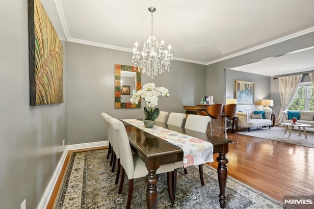 dining room featuring ornamental molding, a chandelier, and wood-type flooring