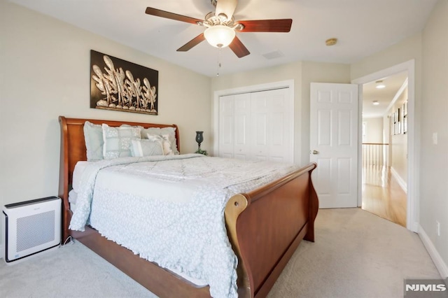 bedroom with ceiling fan, a closet, and light carpet