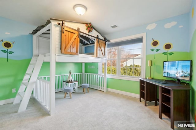 bedroom featuring lofted ceiling, a barn door, and light colored carpet