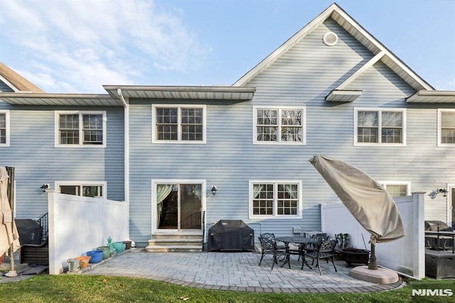 rear view of property with a lawn and a patio