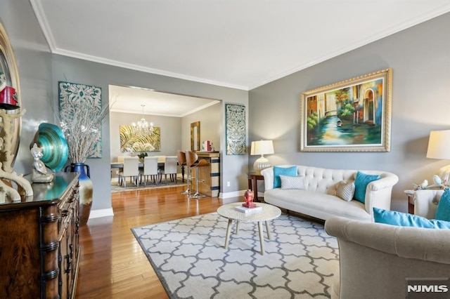 living room featuring a notable chandelier, crown molding, and wood-type flooring