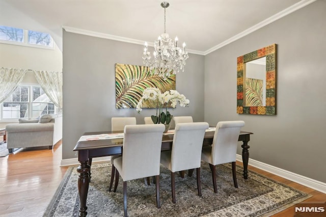 dining space with crown molding, a chandelier, and hardwood / wood-style floors