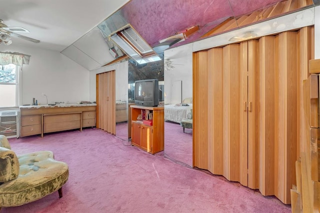 interior space with carpet flooring, lofted ceiling with skylight, and ceiling fan