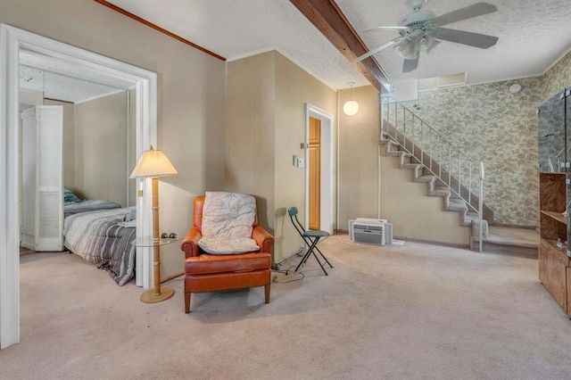 living area featuring a textured ceiling, carpet floors, ceiling fan, and ornamental molding