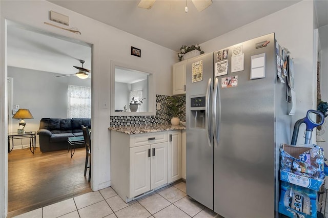 kitchen with white cabinetry, ceiling fan, backsplash, stainless steel fridge, and light wood-type flooring