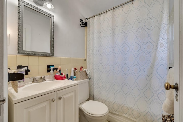 bathroom with vanity, tile walls, and toilet