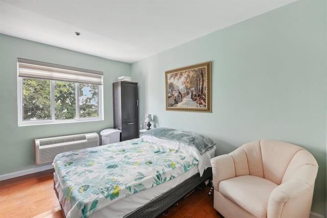 bedroom with hardwood / wood-style flooring and a wall mounted AC