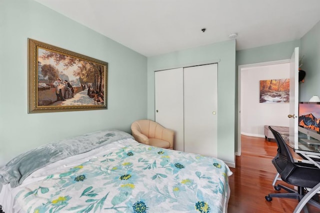 bedroom with wood-type flooring and a closet