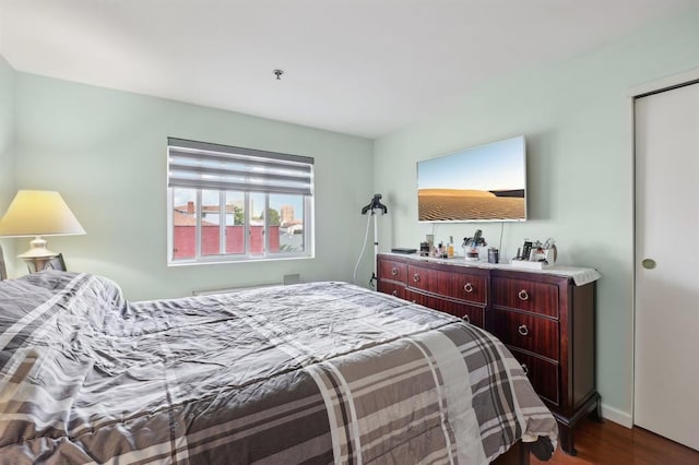 bedroom with dark hardwood / wood-style floors