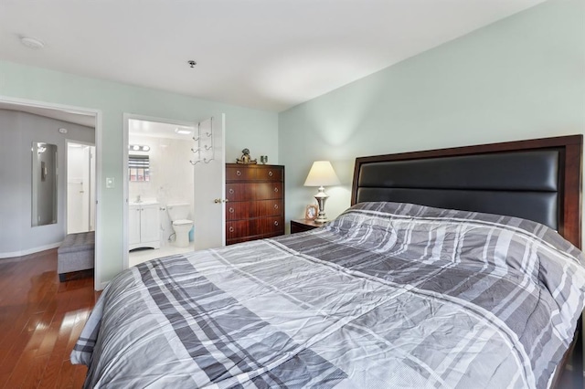 bedroom with dark hardwood / wood-style floors and ensuite bath