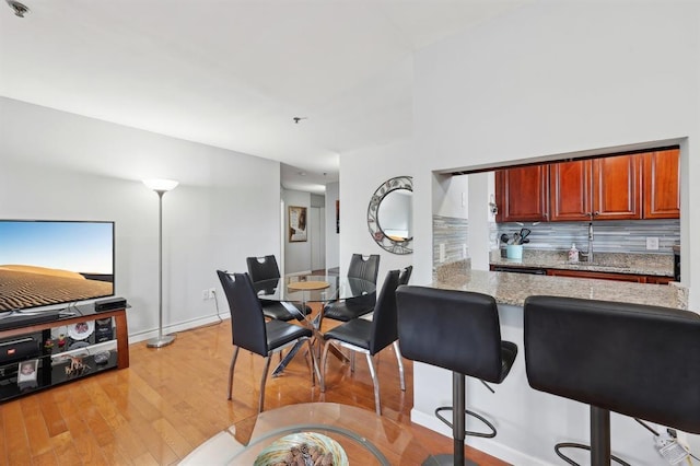 dining area featuring sink and light hardwood / wood-style floors