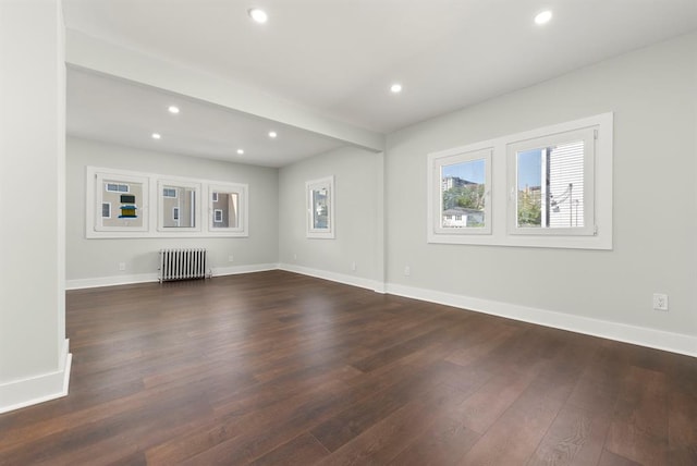 unfurnished living room with dark hardwood / wood-style floors and radiator