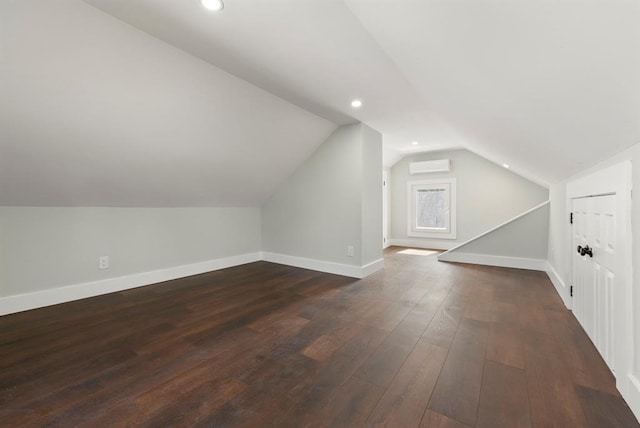 bonus room featuring dark hardwood / wood-style floors, vaulted ceiling, and an AC wall unit