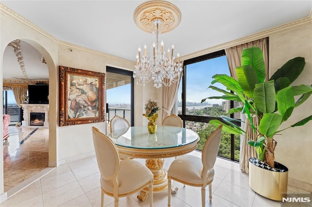 tiled dining area with crown molding and a chandelier