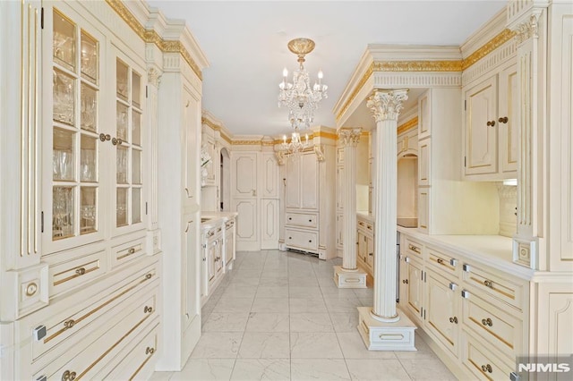 spacious closet featuring ornate columns and a notable chandelier