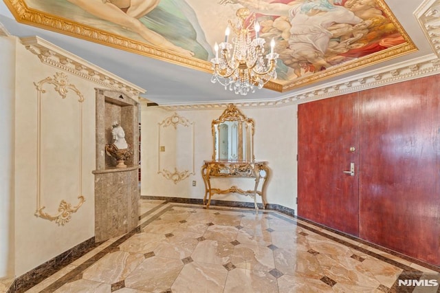 entryway with a raised ceiling, crown molding, and a chandelier