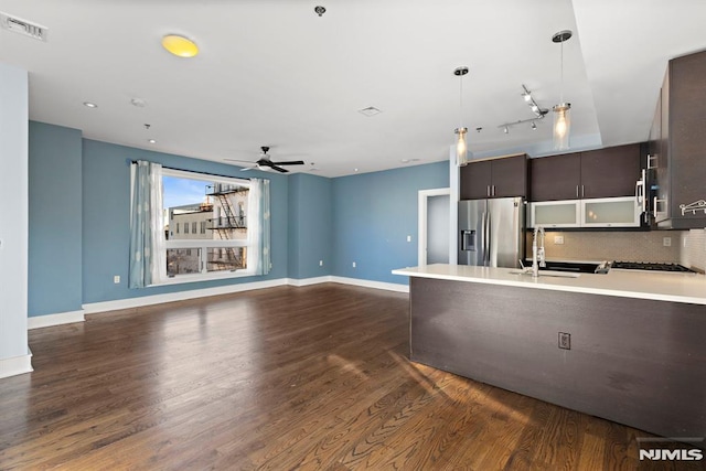 kitchen featuring sink, dark brown cabinetry, tasteful backsplash, dark hardwood / wood-style flooring, and stainless steel fridge with ice dispenser