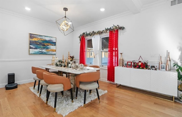 dining space with light hardwood / wood-style floors and ornamental molding