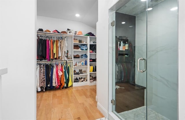 walk in closet featuring hardwood / wood-style floors and lofted ceiling