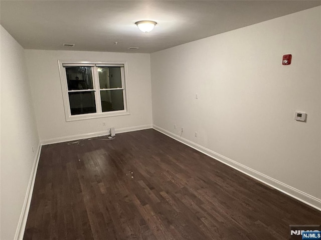 spare room featuring dark hardwood / wood-style flooring