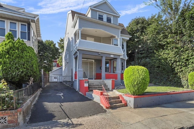 view of front of house featuring a garage, covered porch, and an outdoor structure