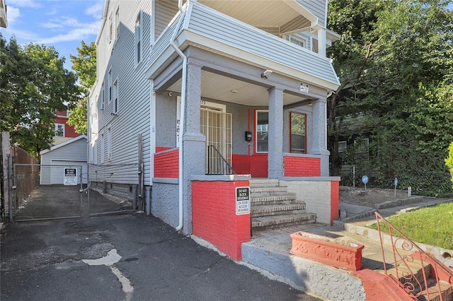 entrance to property featuring covered porch and a balcony