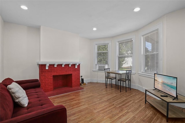 living room featuring a fireplace, light hardwood / wood-style floors, and cooling unit