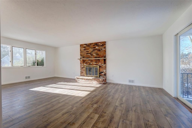 unfurnished living room with dark hardwood / wood-style flooring and a fireplace