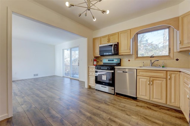 kitchen featuring dishwasher, sink, light wood-type flooring, tasteful backsplash, and range