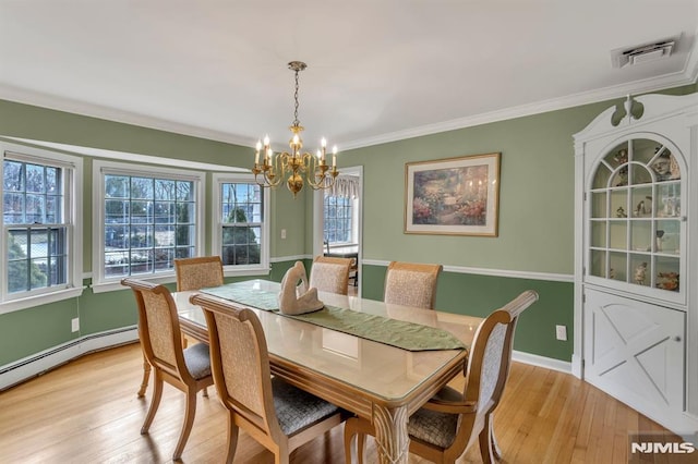 dining space with a chandelier, light wood-type flooring, a baseboard radiator, and crown molding