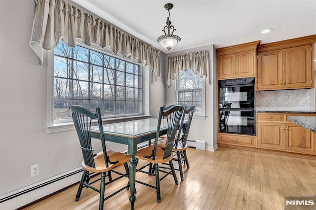 dining area featuring a baseboard radiator and light hardwood / wood-style floors