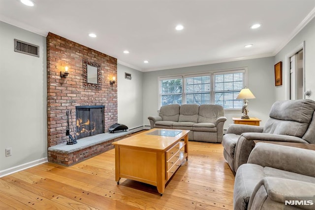 living room with crown molding, light wood-type flooring, and a brick fireplace