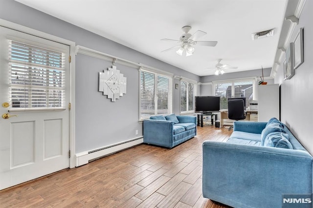 living room featuring wood-type flooring, ceiling fan, and a baseboard heating unit