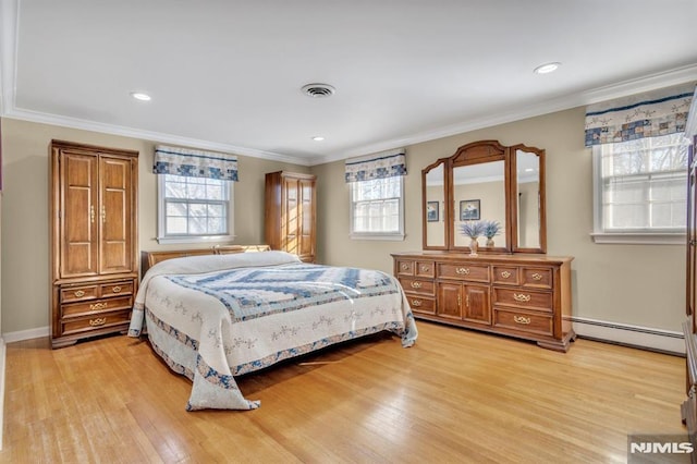 bedroom with light hardwood / wood-style floors, multiple windows, and a baseboard heating unit