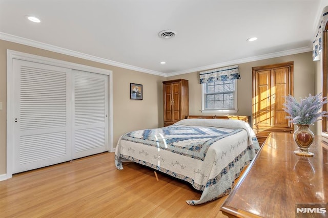 bedroom featuring light hardwood / wood-style floors, a closet, and ornamental molding