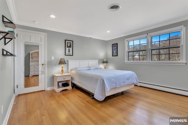 bedroom with a baseboard radiator, ornamental molding, and light hardwood / wood-style floors