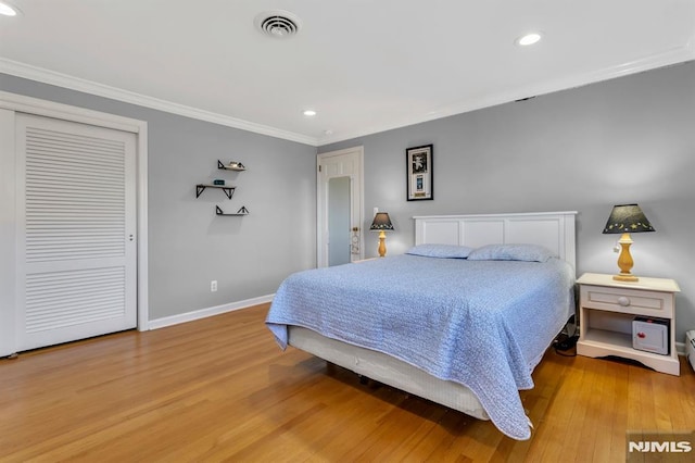 bedroom featuring light hardwood / wood-style floors, a closet, and ornamental molding