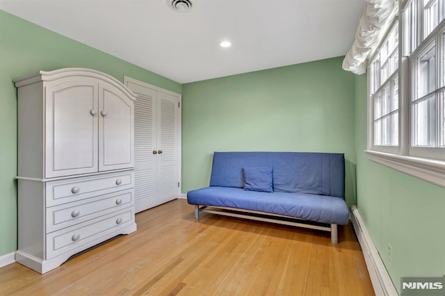 living area featuring light wood-type flooring and a baseboard heating unit