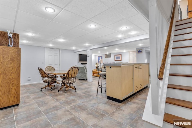 dining space featuring a drop ceiling and bar area