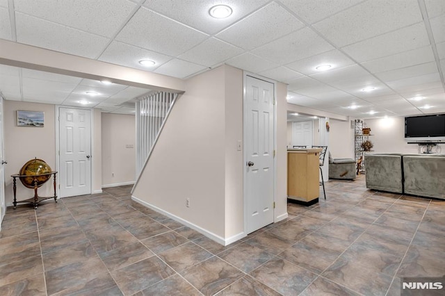 basement with a paneled ceiling