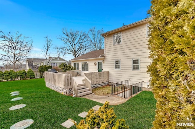 rear view of house featuring a deck and a yard