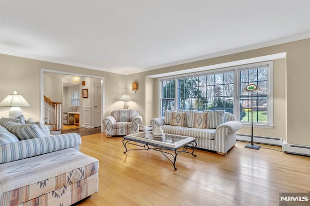 living room featuring crown molding, baseboard heating, and light hardwood / wood-style flooring