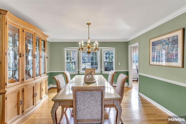 dining space featuring ornamental molding, light wood-type flooring, baseboard heating, and a notable chandelier