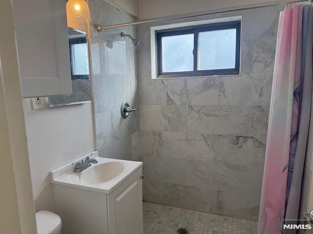 bathroom with toilet, vanity, and curtained shower