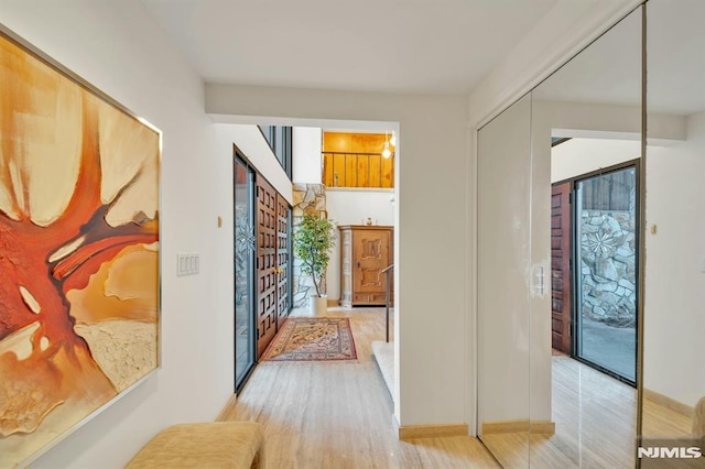 hallway featuring light wood-type flooring and a wealth of natural light