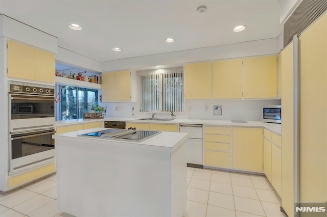 kitchen with white double oven, a center island, light tile patterned floors, black electric stovetop, and sink